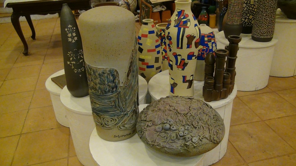 almost flat piece with reliefs, next to one of white cylindrical and with reliefs