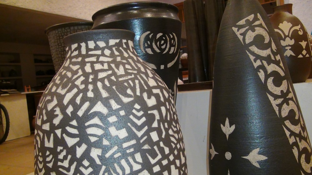 detail of three dark-colored ceramics with abstract white paints